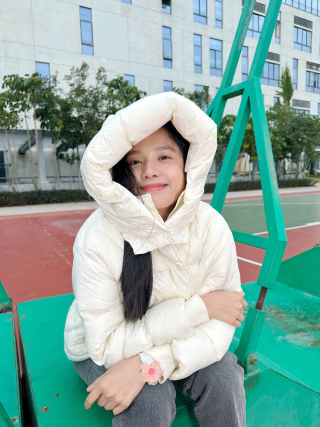 张婧仪身穿羽绒服笑容灿烂 双手托腮显俏皮