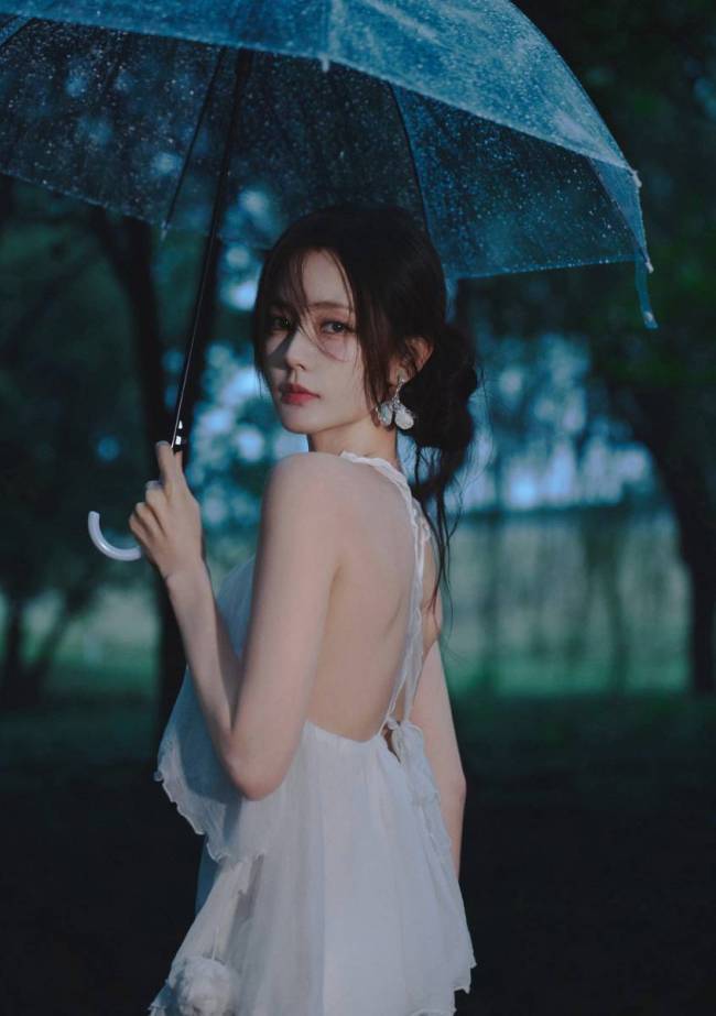 李一桐穿白色吊带裙身材窈窕 雨中撑伞氛围感十足