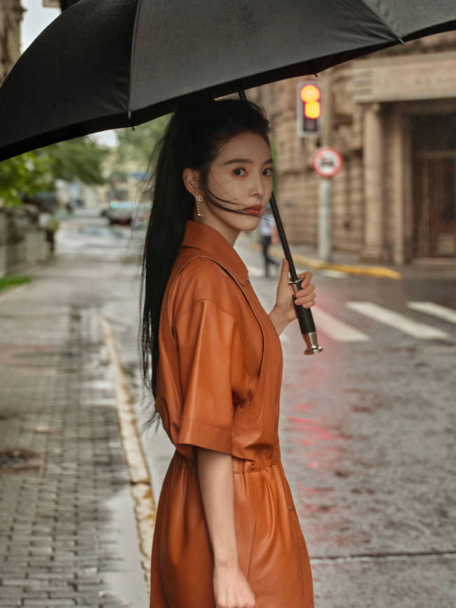 章若楠穿橘色皮裙漫步上海 手撑雨伞步伐轻盈灵动